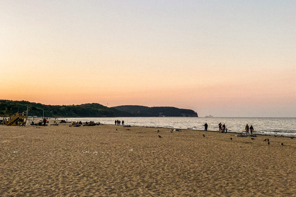 Plaża w Sopocie tuż po zachodzie słońca. W oddali widać klif orłowski i prom Stena Line wpływający do portu w Gdyni